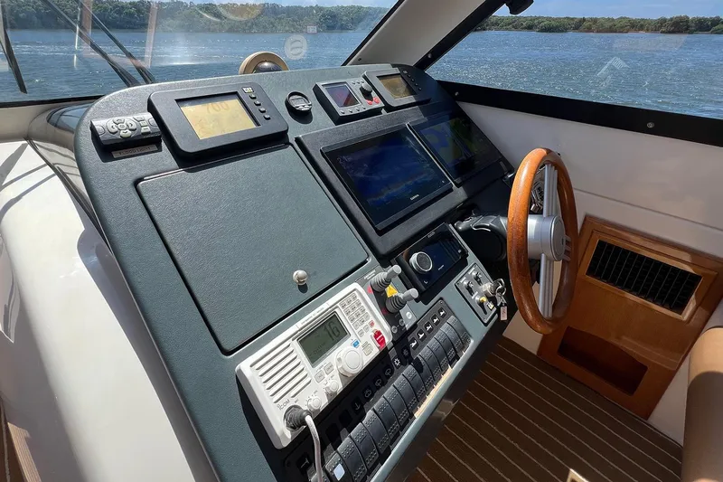 Kahala Yacht Photos Pics Dashboard of a 2005 Maritimo M60 yacht with navigation controls and wooden steering wheel.