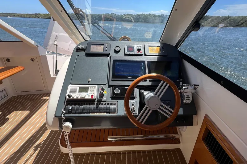 Kahala Yacht Photos Pics Helm of 2005 Maritimo M60 yacht with navigation controls and wooden steering wheel.