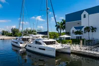2016 Leopard 40 catamaran docked by a marina with palm trees and blue sky.