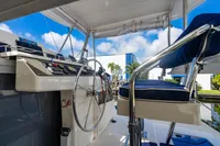 Helm of 2016 Leopard 40 catamaran with steering wheel and controls, under blue sky.