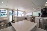 Spacious interior of a 2016 Leopard 40 catamaran with modern kitchen and dining area.