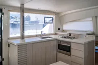 Modern kitchen interior of 2016 Leopard 40 catamaran with stove, oven, and large window view.