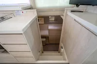 Interior of 2016 Leopard 40 yacht, featuring a compact kitchen and wooden cabinetry.