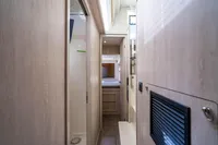 Narrow hallway inside 2016 Leopard 40 yacht, featuring light wood paneling and compact design.