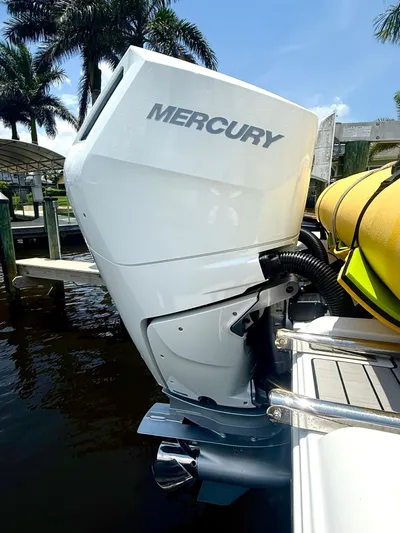  Yacht Photos Pics 2024 Sportsman 322 Open with Mercury outboard engine, docked near palm trees.