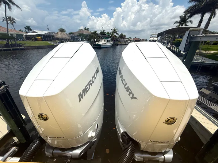  Yacht Photos Pics Twin Mercury outboard engines on a 2024 Sportsman 322 Open boat, docked by a scenic canal.