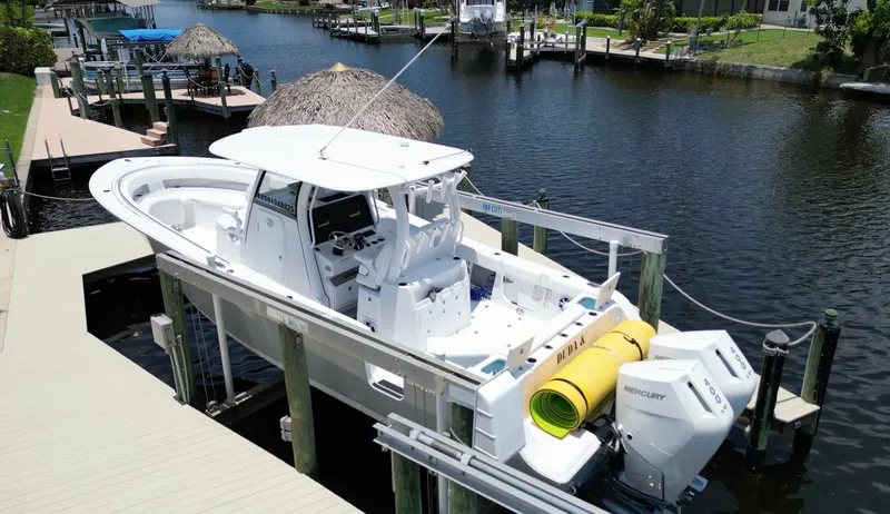 Yacht Photos Pics 2024 Sportsman 322 Open boat docked on a canal with dual Mercury engines.