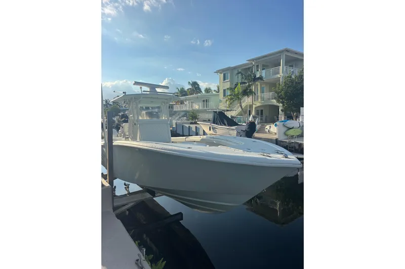  Yacht Photos Pics 2012 Yellowfin 32 Offshore boat docked near waterfront homes under a clear sky.