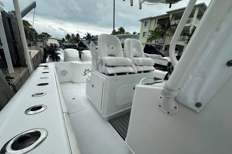  Yacht Photos Pics 2012 Yellowfin 32 Offshore boat with white seating and rod holders, docked near waterfront homes.
