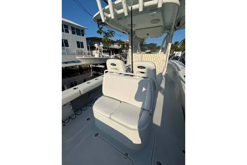  Yacht Photos Pics 2012 Yellowfin 32 Offshore boat interior with seating and console, docked near waterfront homes.