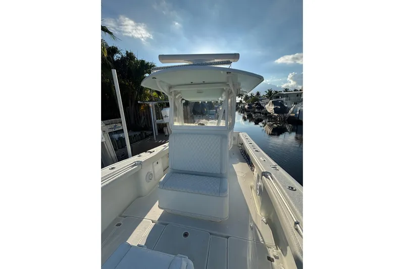  Yacht Photos Pics 2012 Yellowfin 32 Offshore boat interior with seating, docked by a calm waterfront.