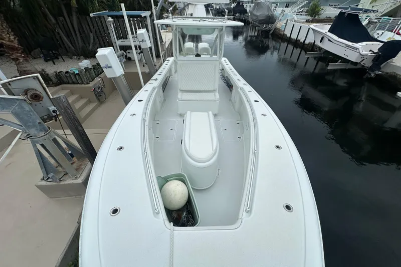  Yacht Photos Pics 2012 Yellowfin 32 Offshore boat docked in a canal, showcasing spacious deck layout.
