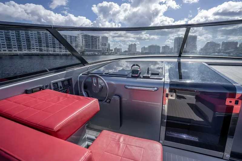 Warriors At Sea Yacht Photos Pics 2016 VanDutch 55 yacht cockpit with red seats, sleek dashboard, and city skyline view.
