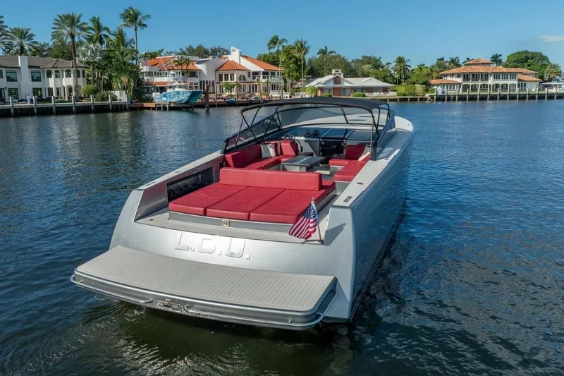 Warriors At Sea Yacht Photos Pics Luxury 2016 VanDutch 55 yacht with red seating, docked near waterfront homes.