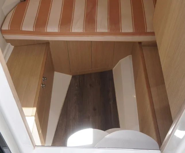 Sea)3 Yacht Photos Pics Interior cabin of 2022 Aquila 32 Sport with wood finish and striped upholstery.