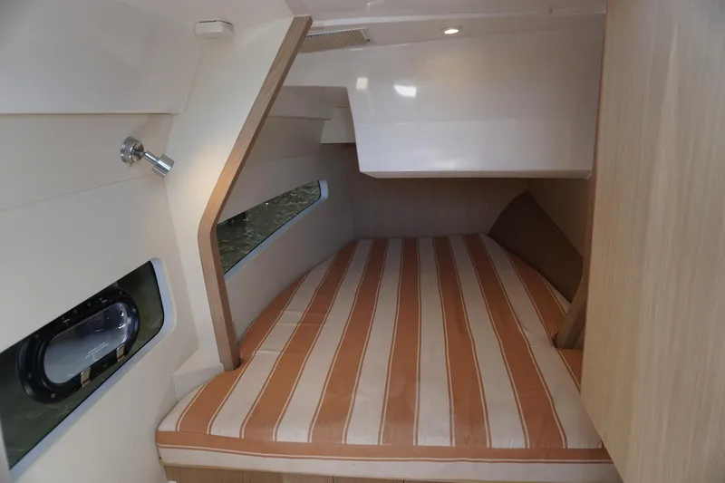 Sea)3 Yacht Photos Pics Cabin interior of 2022 Aquila 32 Sport with striped bedding and modern design.