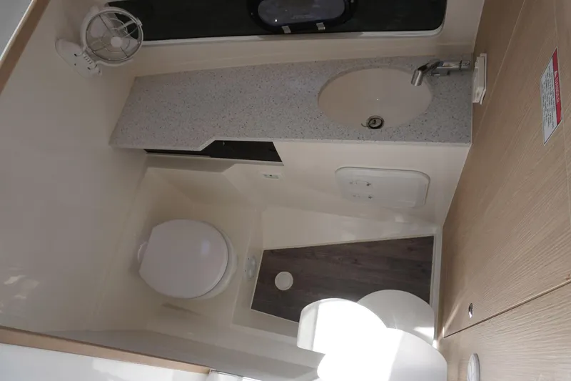 Sea)3 Yacht Photos Pics Compact bathroom in 2022 Aquila 32 Sport boat with sink, toilet, and storage.