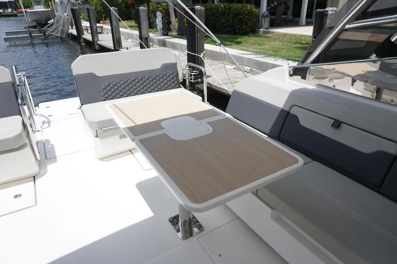 Sea)3 Yacht Photos Pics Aquila 32 Sport 2022 boat interior with seating and table, docked at marina.