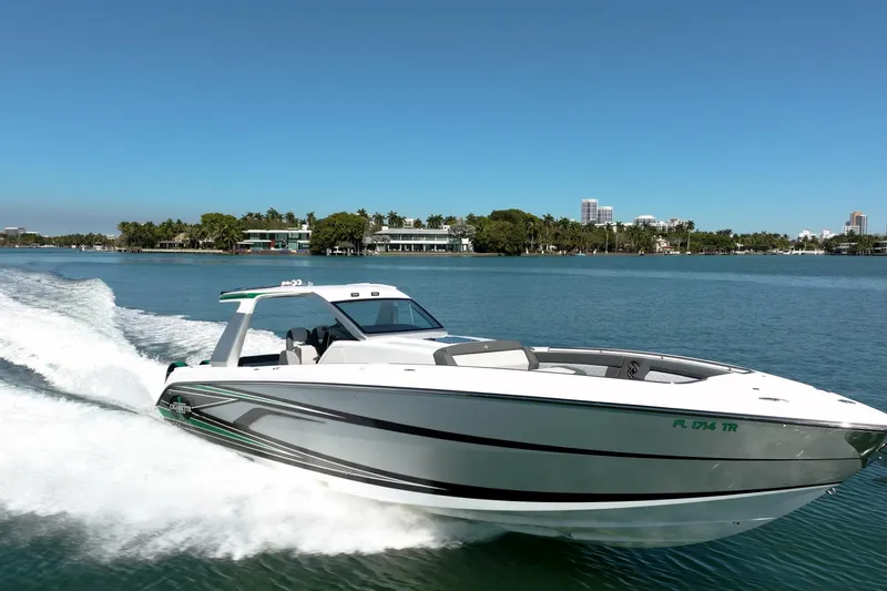  Yacht Photos Pics 2024 Cigarette 42' Auroris speedboat cruising on a sunny day in a scenic waterway.