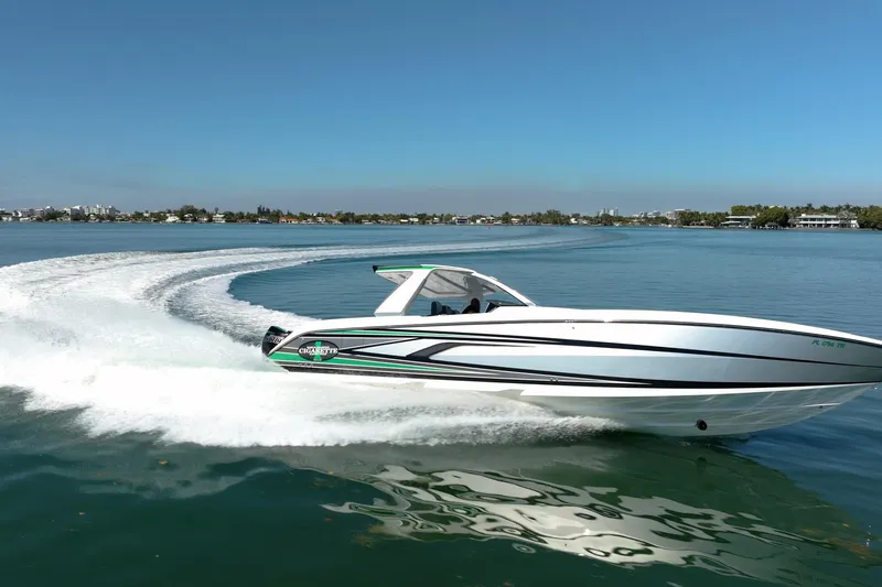  Yacht Photos Pics 2024 Cigarette 42' Auroris speedboat cruising on a clear blue lake.