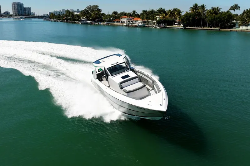  Yacht Photos Pics 2024 Cigarette 42' Auroris speedboat cruising on clear blue water.