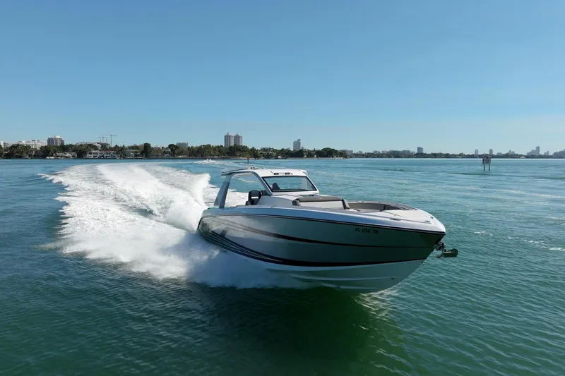  Yacht Photos Pics 2024 Cigarette 42' Auroris speedboat cruising on clear blue water.