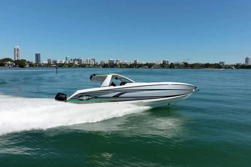  Yacht Photos Pics 2024 Cigarette 42' Auroris speedboat cruising on a sunny day near city skyline.