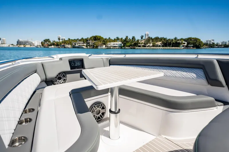  Yacht Photos Pics 2024 Cigarette 42' Auroris boat interior with seating and table, overlooking scenic waterfront.