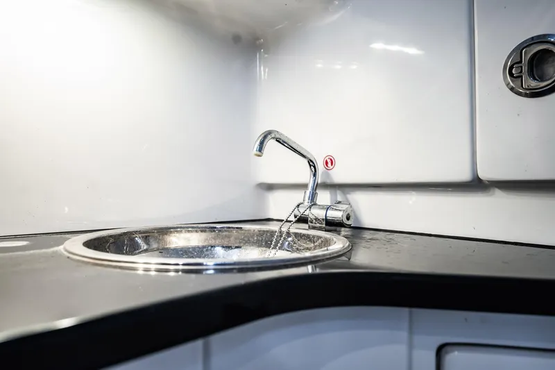  Yacht Photos Pics Modern sink in 2024 Cigarette 42' Auroris boat interior, featuring sleek design and chrome faucet.