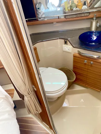 Seaburd Yacht Photos Pics 2018 Ranger Tugs R-29 S bathroom with toilet, sink, and wooden cabinetry.
