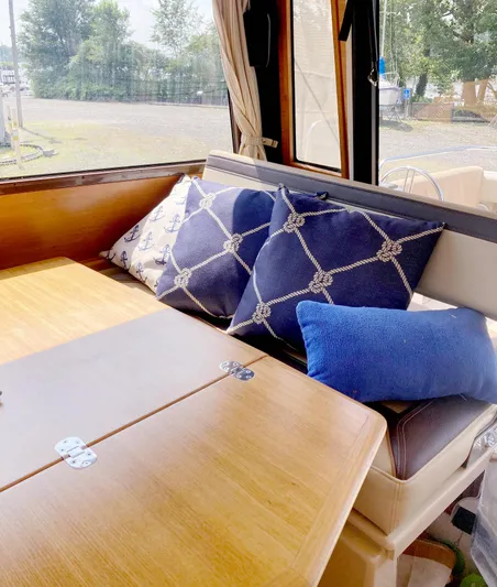 Seaburd Yacht Photos Pics Interior of 2018 Ranger Tugs R-29 S with nautical-themed cushions on a wooden table.