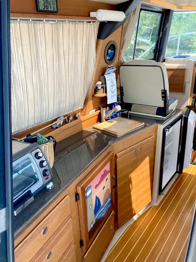 Seaburd Yacht Photos Pics 2018 Ranger Tugs R-29 S interior kitchen with wooden cabinetry and appliances.