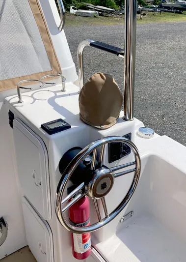 Seaburd Yacht Photos Pics Steering console of 2018 Ranger Tugs R-29 S with chrome wheel and fire extinguisher.