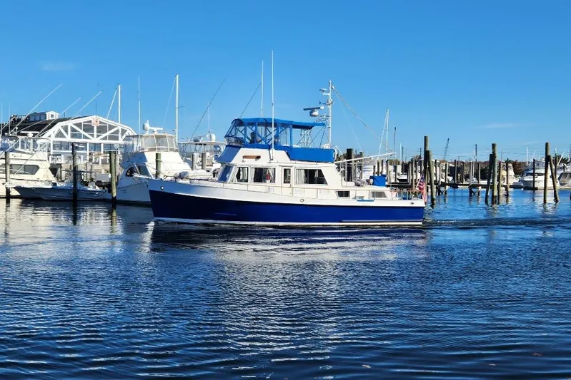 Burnin Daylight Yacht Photos Pics 1983 Grand Banks 42 Classic yacht cruising in a marina under clear blue skies.