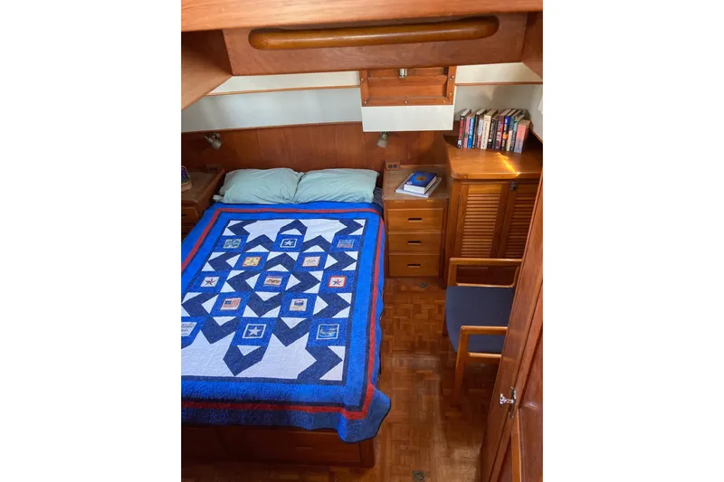 Burnin Daylight Yacht Photos Pics Cozy cabin interior of 1983 Grand Banks 42 Classic with quilted bedspread and wooden furnishings.