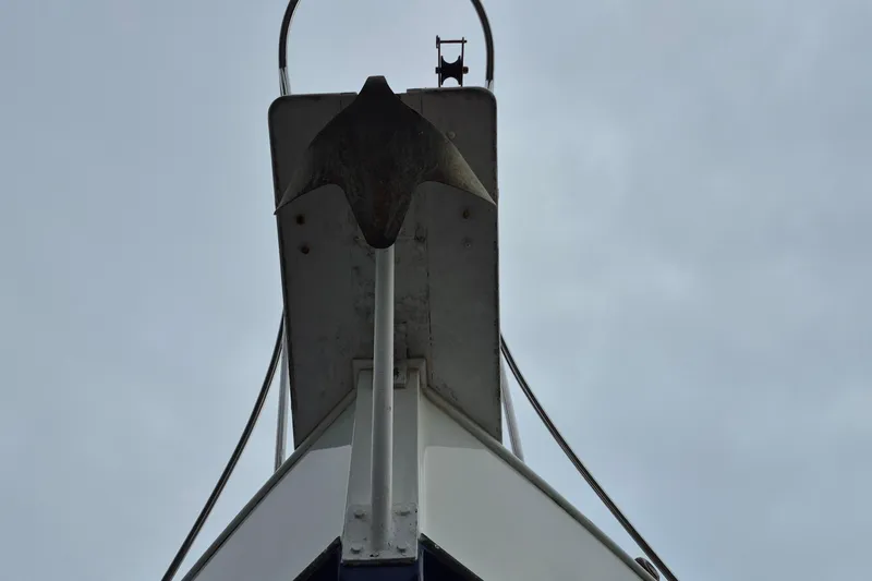 Burnin Daylight Yacht Photos Pics Bow view of 1983 Grand Banks 42 Classic yacht with anchor against cloudy sky.