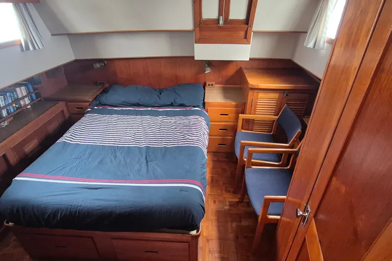 Burnin Daylight Yacht Photos Pics Cozy cabin interior of 1983 Grand Banks 42 Classic yacht with bed and wooden furnishings.