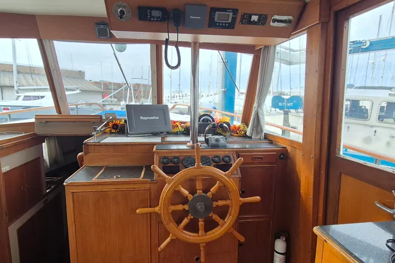 Burnin Daylight Yacht Photos Pics Interior helm of 1983 Grand Banks 42 Classic yacht with wooden wheel and navigation equipment.