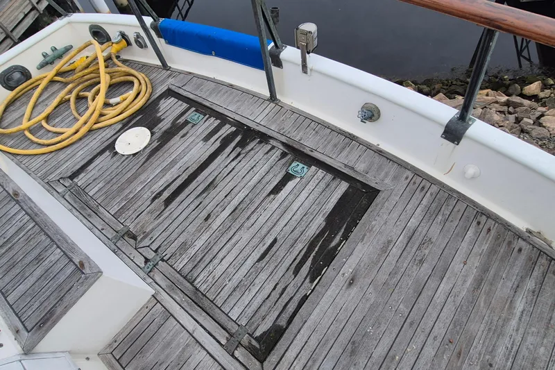 Burnin Daylight Yacht Photos Pics 1983 Grand Banks 42 Classic deck with weathered wood and coiled yellow hose.