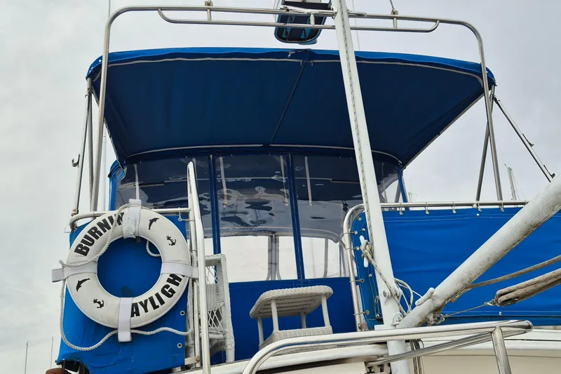Burnin Daylight Yacht Photos Pics 1983 Grand Banks 42 Classic boat with blue canopy and lifebuoy.