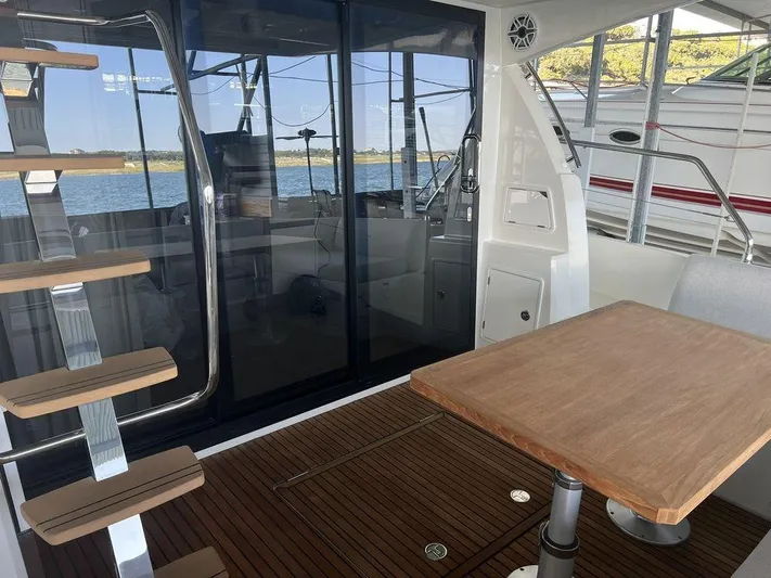 Velkommen Yacht Photos Pics Prestige 460F 2022 yacht interior with wooden table and stairs, overlooking water.