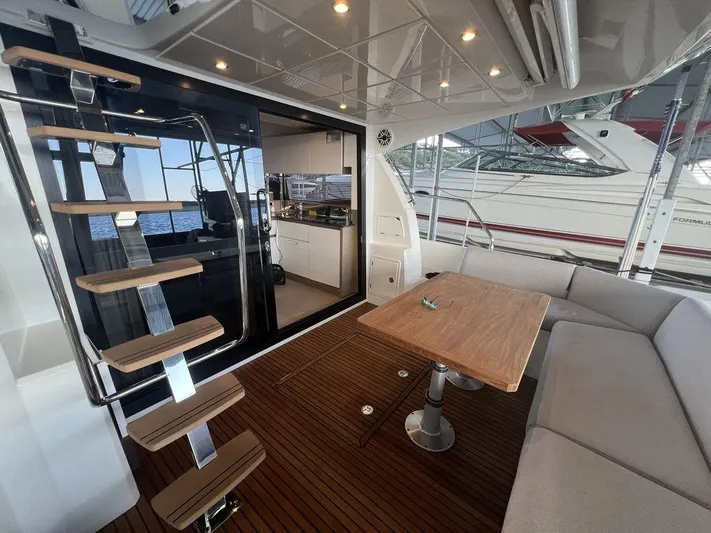 Velkommen Yacht Photos Pics Luxury yacht interior with wooden deck, modern staircase, and seating area on a 2022 Prestige 460F.