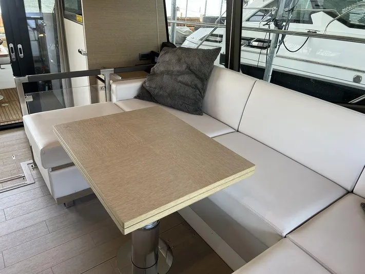Velkommen Yacht Photos Pics Luxurious 2022 Prestige 460F yacht interior with white seating and wooden table.