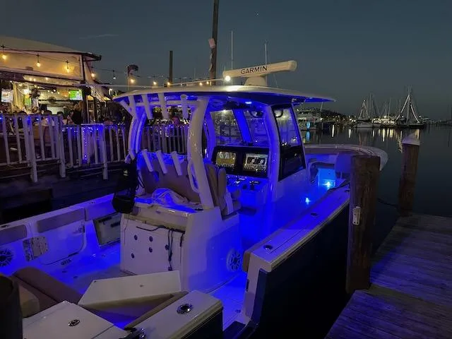  Yacht Photos Pics 2023 Sportsman 322 Open boat docked at night with blue LED lights.