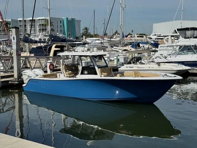  Yacht Photos Pics 2023 Sportsman 322 Open boat docked in a marina, surrounded by other vessels.