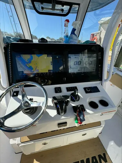  Yacht Photos Pics Boat cockpit with navigation screens, steering wheel, and controls, Sportsman 2023 model.