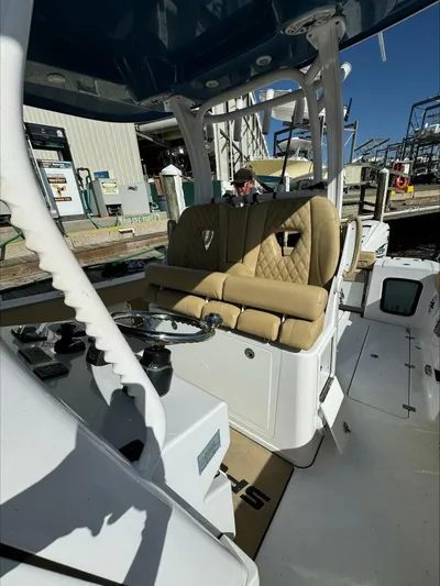  Yacht Photos Pics 2023 Sportsman boat interior with tan seats and steering wheel at a marina.