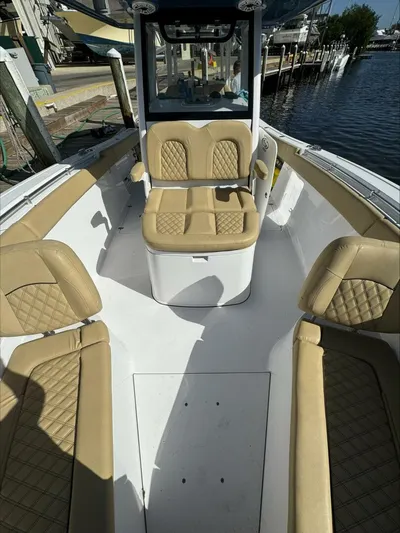  Yacht Photos Pics 2023 Sportsman boat interior with tan quilted seats, docked by the water.