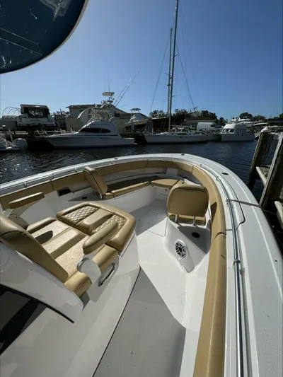  Yacht Photos Pics 2023 Sportsman boat with tan seating docked at a marina under clear blue sky.