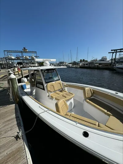  Yacht Photos Pics 2023 Sportsman boat docked at marina with tan seating and clear blue sky.